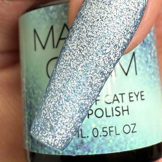 Close-up of a glittery nail polish with a visible brand name on a blurred background