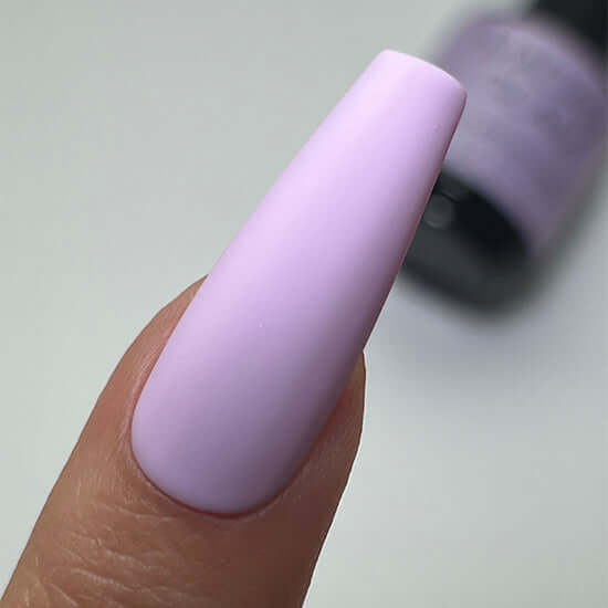 Close-up of a hand with a lavender-colored nail on a neutral background