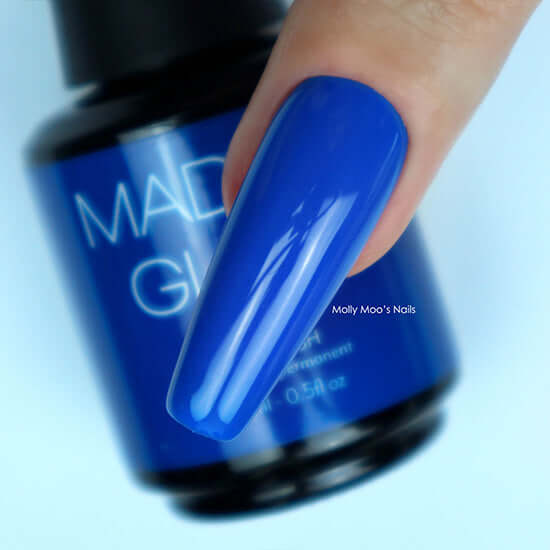 Blue nail polish with a blurred bottle in the background