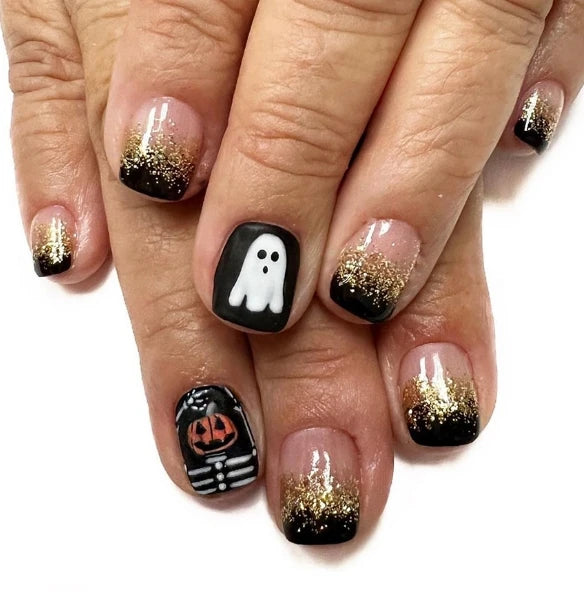 Nails with Halloween-themed designs including ghosts and jack-o'-lanterns on a white background.