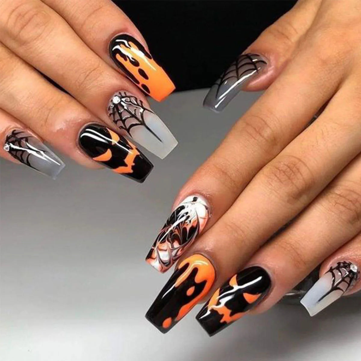 Halloween-themed nail art on a gray background
