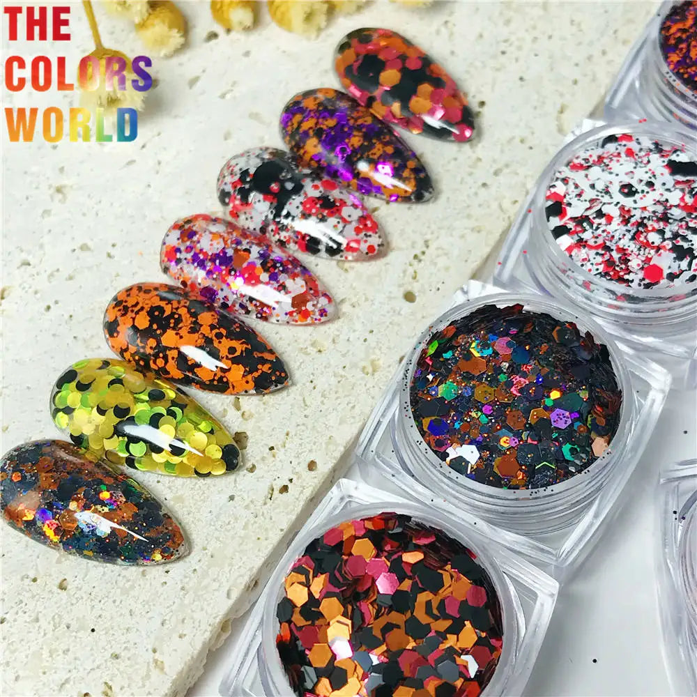 Colorful glittery nail art designs on a white surface with 'The Colors World' branding.