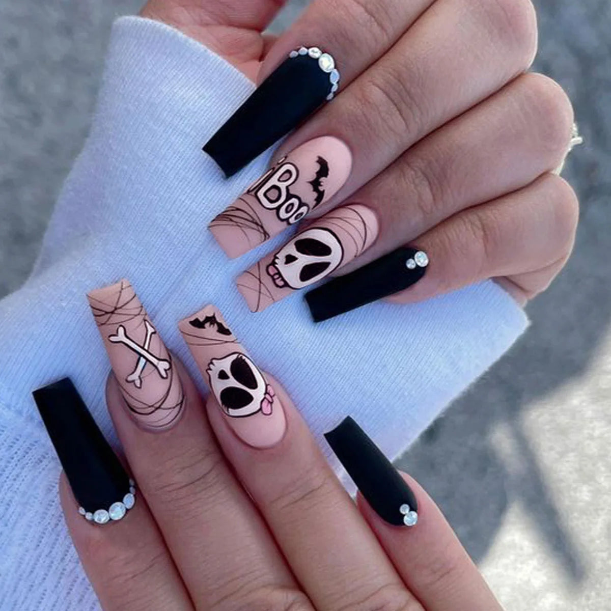 Nails with Halloween-themed designs on a light blue background