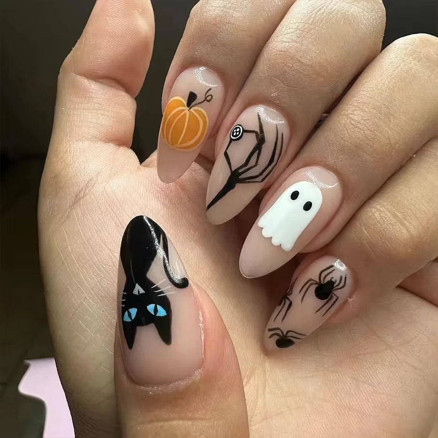 Halloween-themed nail art on a hand with pumpkins, ghosts, and cats.