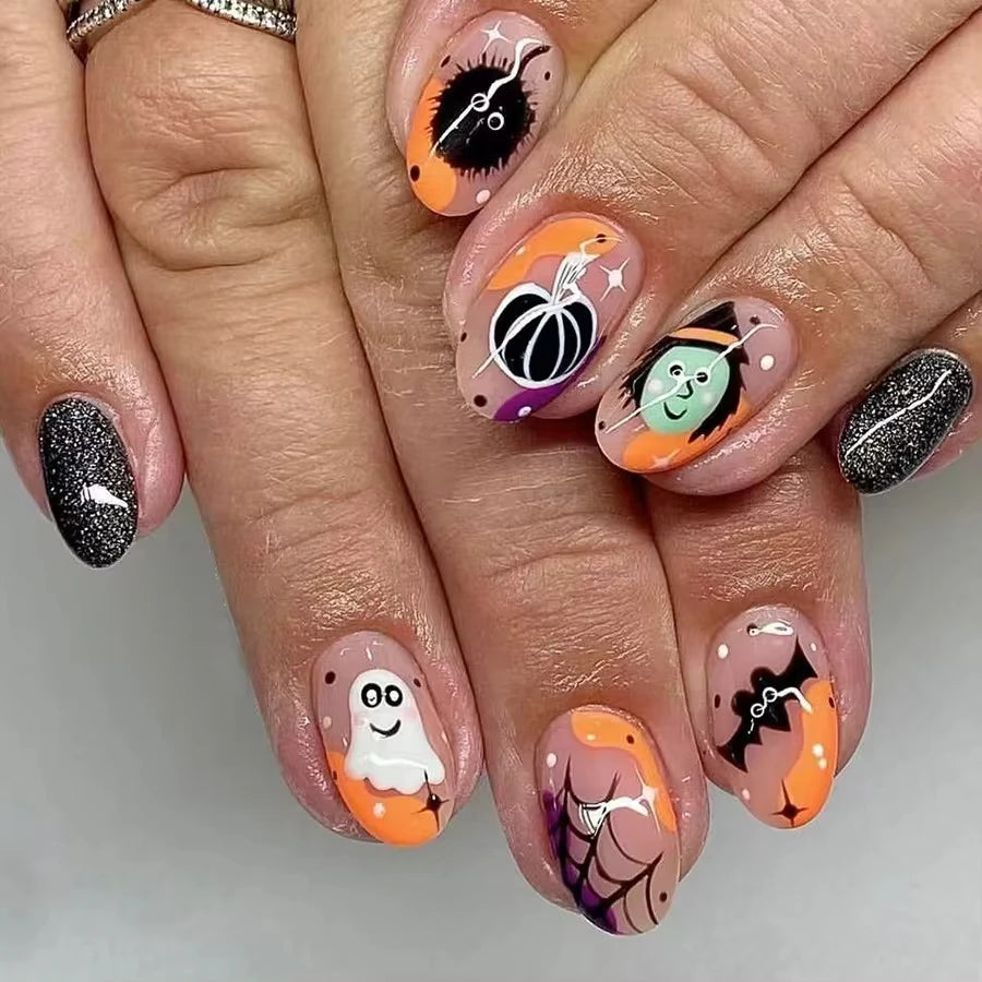 Halloween-themed nail art on a person's hand with pumpkins, ghosts, and witch hats.