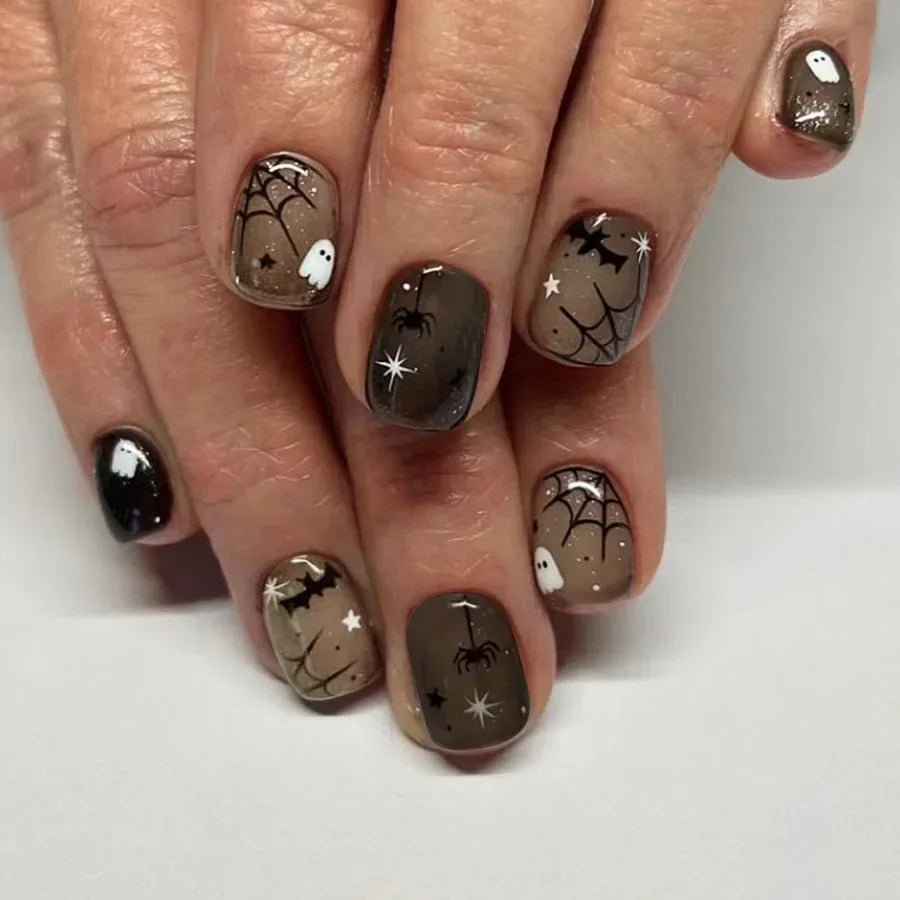 Nails with Halloween-themed designs on a white background