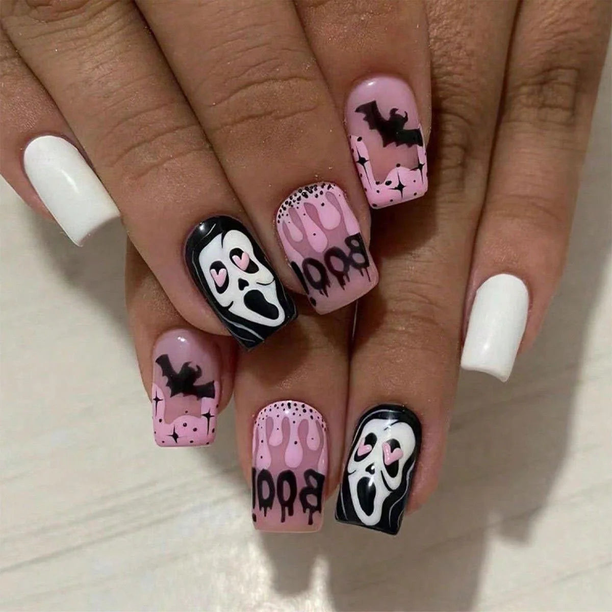 Nails with Halloween-themed designs on a light background