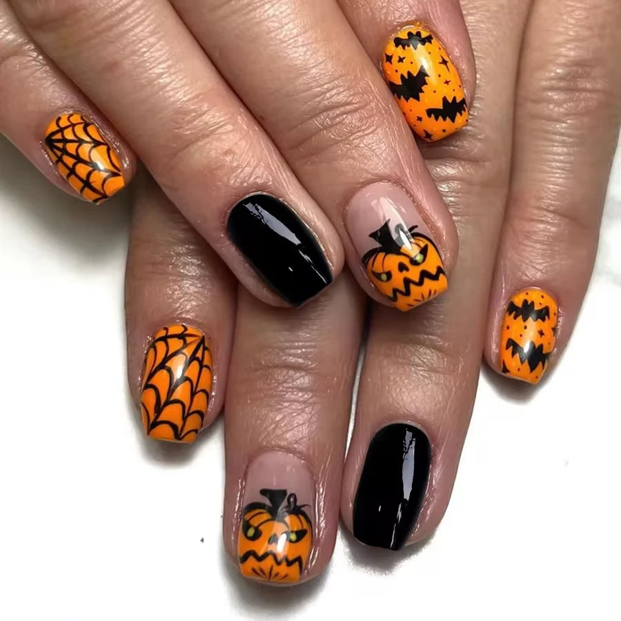 Halloween-themed nail art with pumpkins and spider webs on a white background