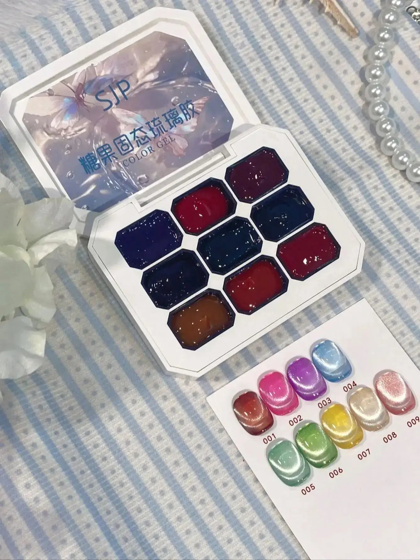 Set of watercolor paints in a compact case on a striped fabric background