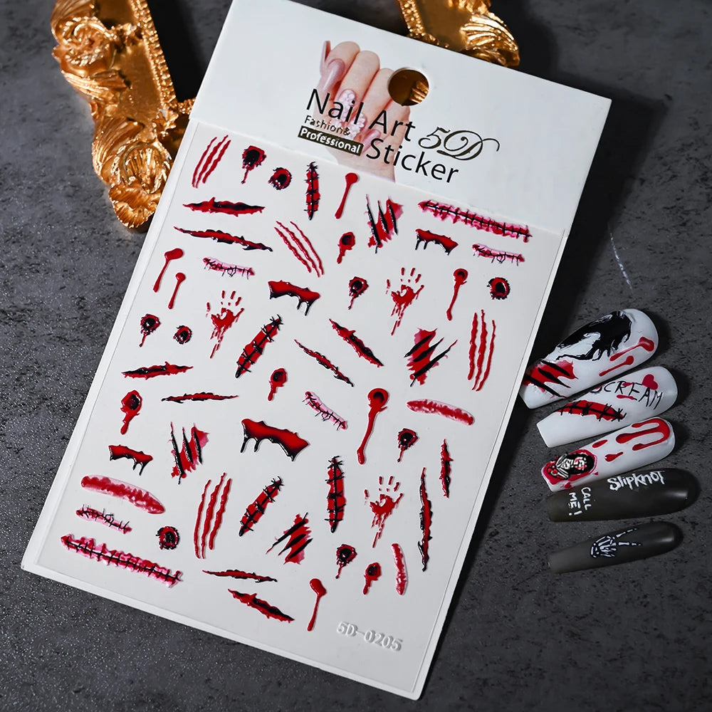 Nail art stickers with blood and horror-themed designs on a dark surface.
