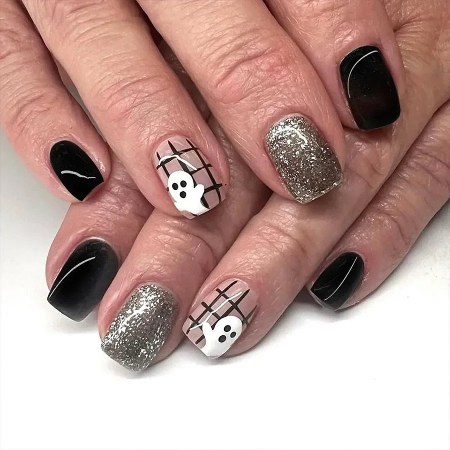 Nails with black, silver, and white designs on a white background