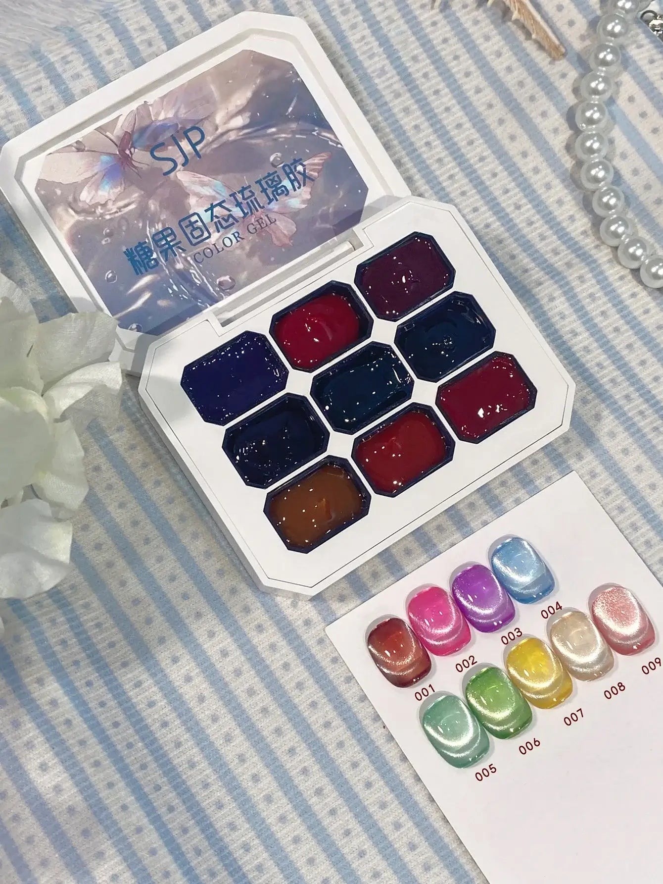 Set of watercolor paints in a white case on a striped fabric background