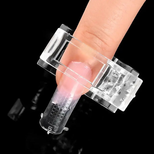 Clear nail drill device on a finger against a black background