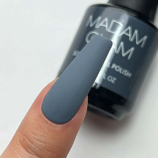 Nail polish with a brush applicator and 'MADAM' branding on a white background