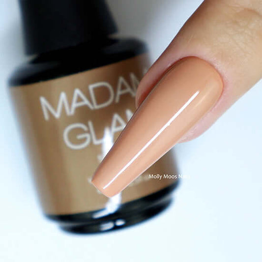 Nail polish bottle with a beige nail color, brand 'Molly Moos' visible