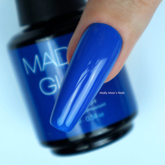 Blue nail polish with a blurred bottle in the background