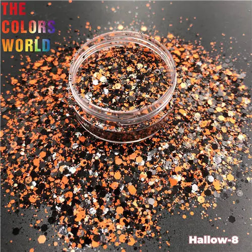 Glitter container with orange, black, and silver glitter on a dark background