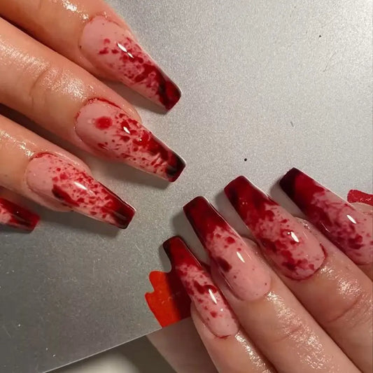 halloween Nails with red dripping blood speckled design on a neutral background