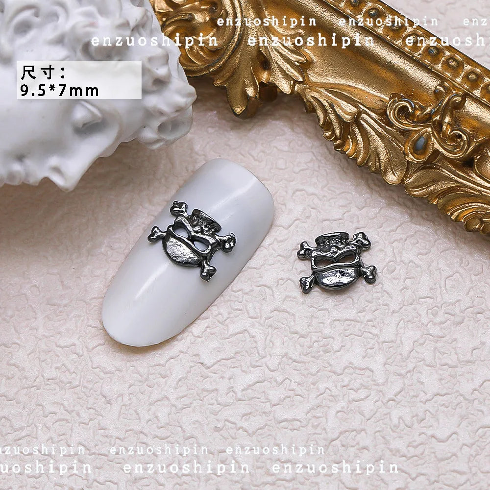 Nail art design with skull and crossbones decorations on a white nail tip, with 'enzuoshipin' branding.