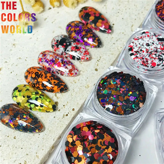 Colorful glittery nail art designs on a white surface with 'The Colors World' branding.