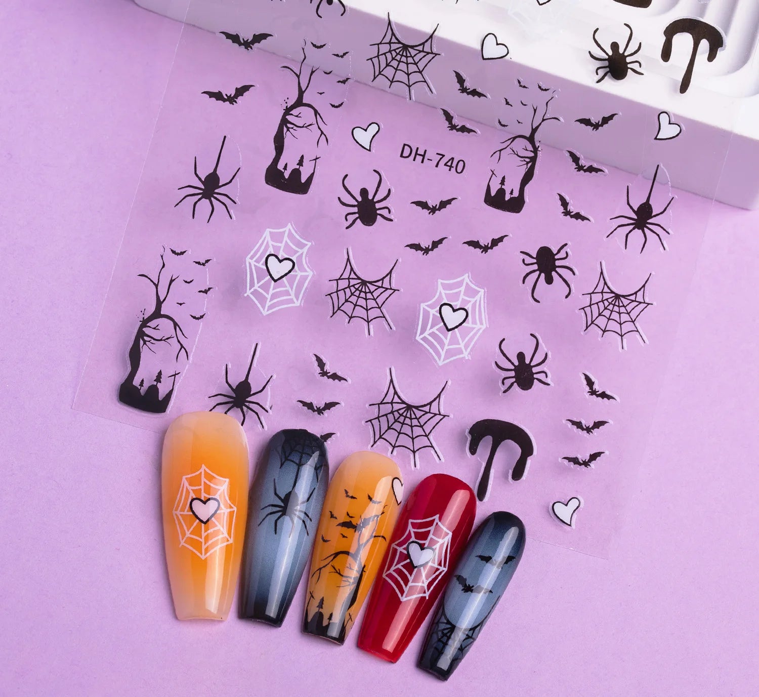 Halloween-themed nail art stickers on a pink background with matching nail designs.