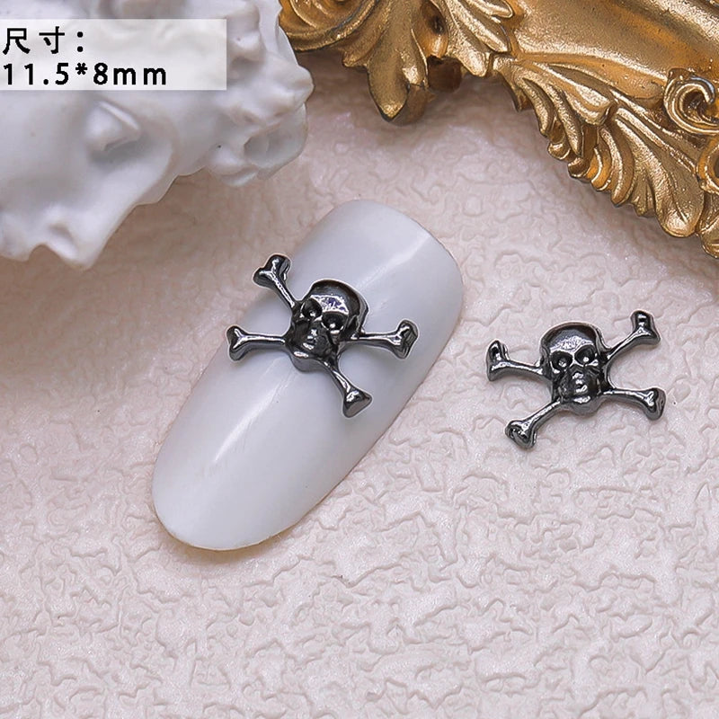 Skull and crossbones nail art design on a white nail with gold decorative background