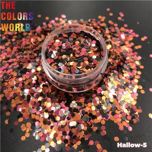 Clear container of glitter with colorful confetti on a black background, featuring 'The Colors World' branding.