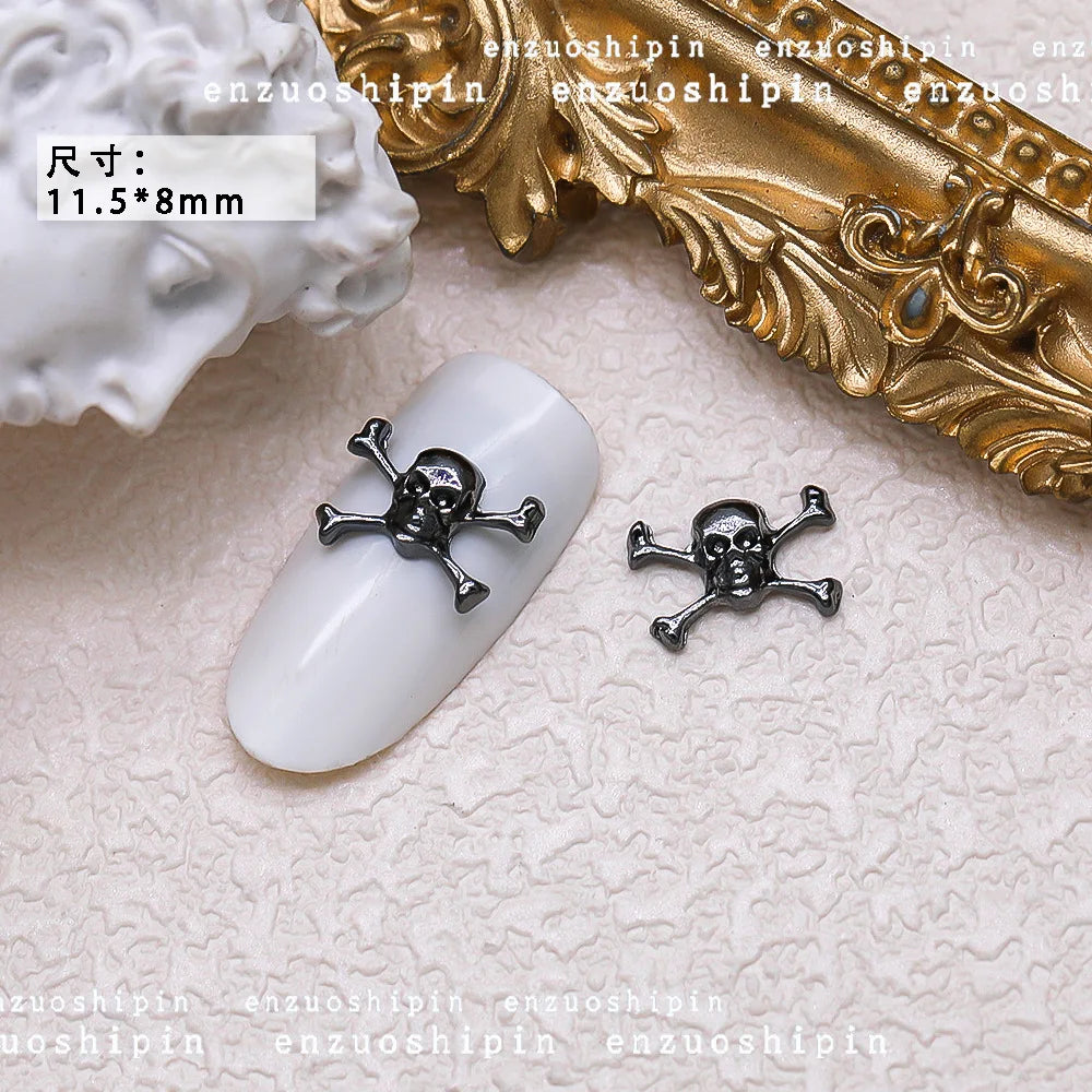 Nail art decorations with skull designs on a textured surface.