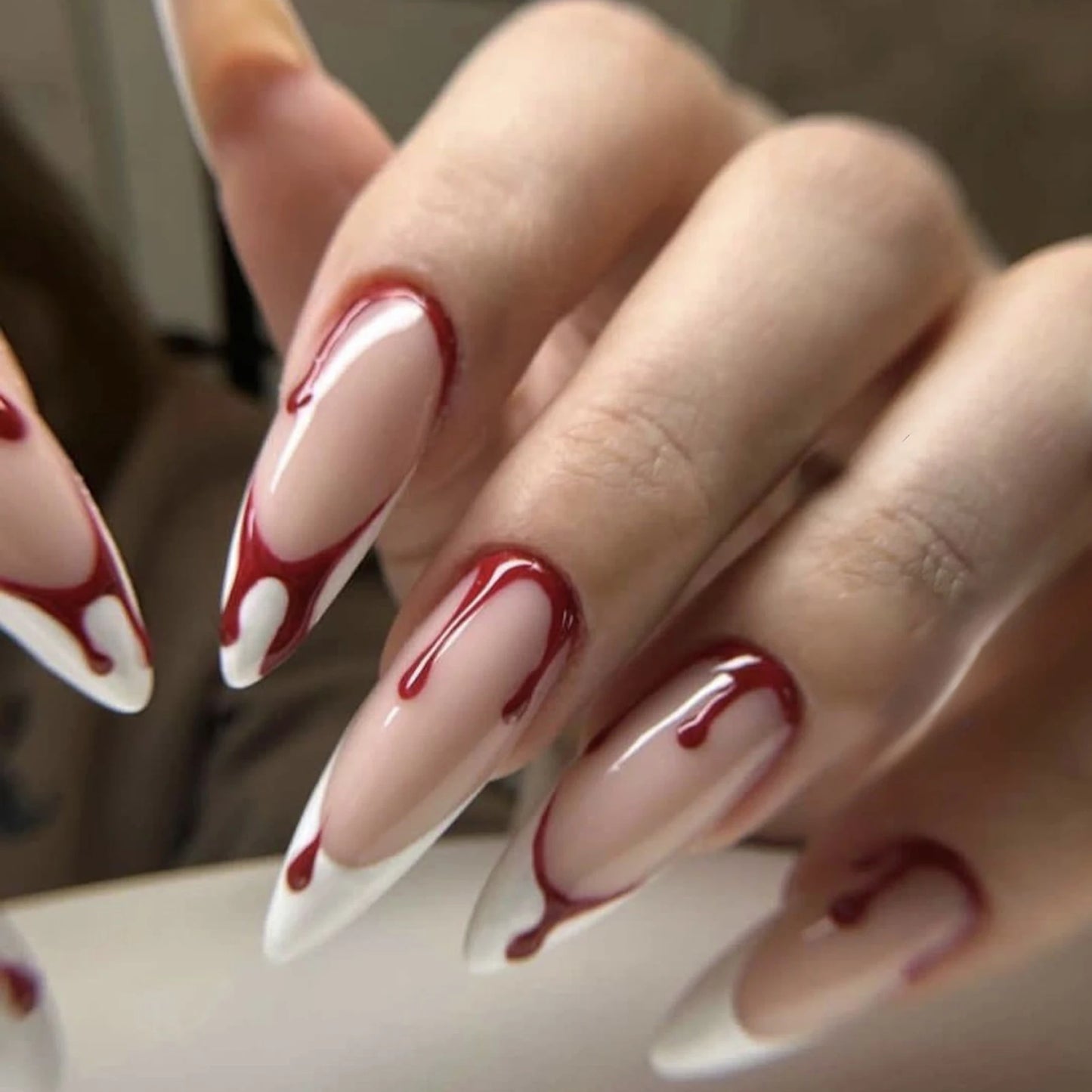 Close-up of hands with red and white nail design