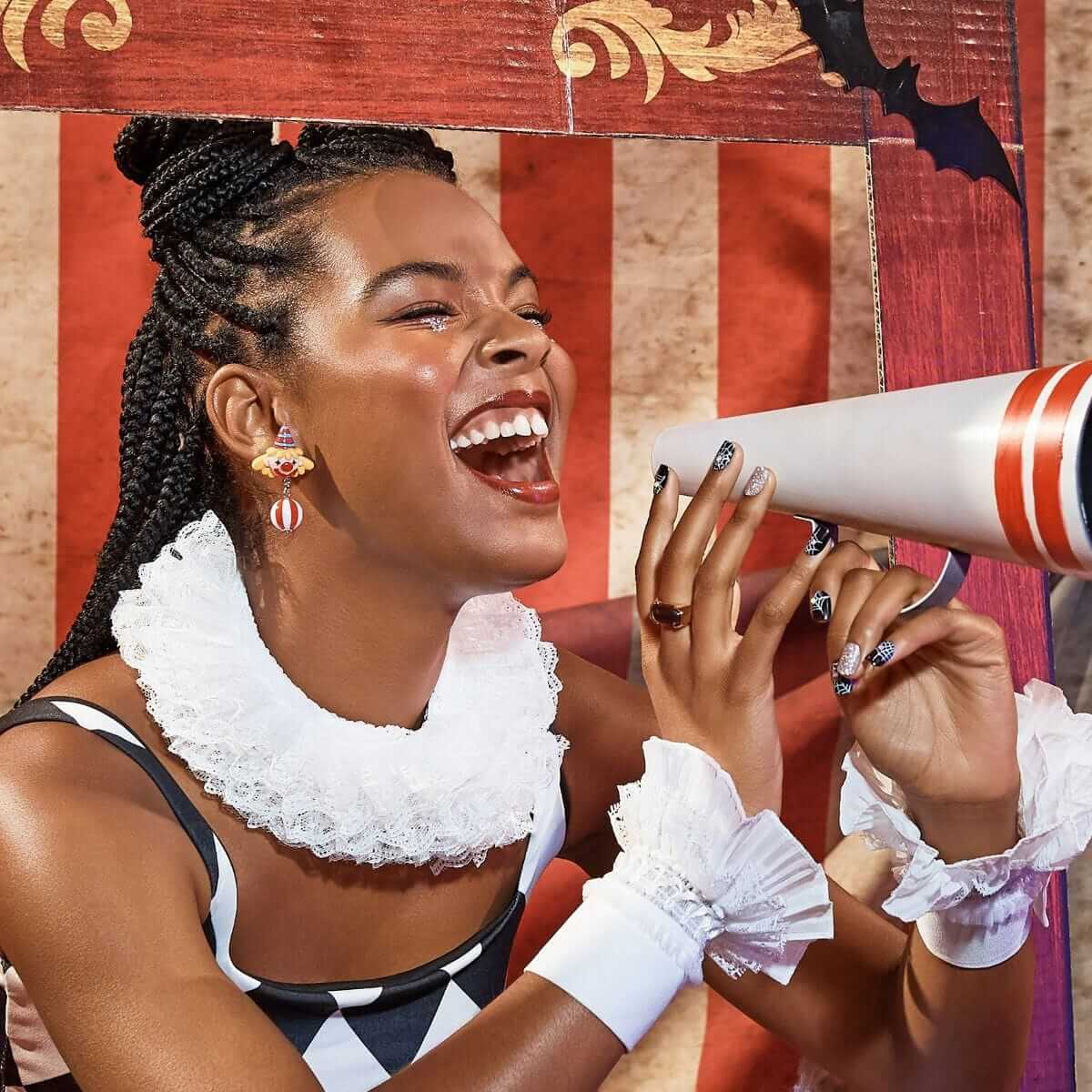 Woman in a costume with a megaphone against a decorative background