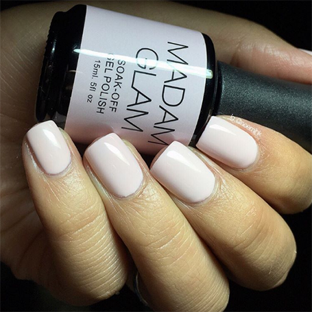 MADAM GLAM nail polish bottle held by a hand with beige nails